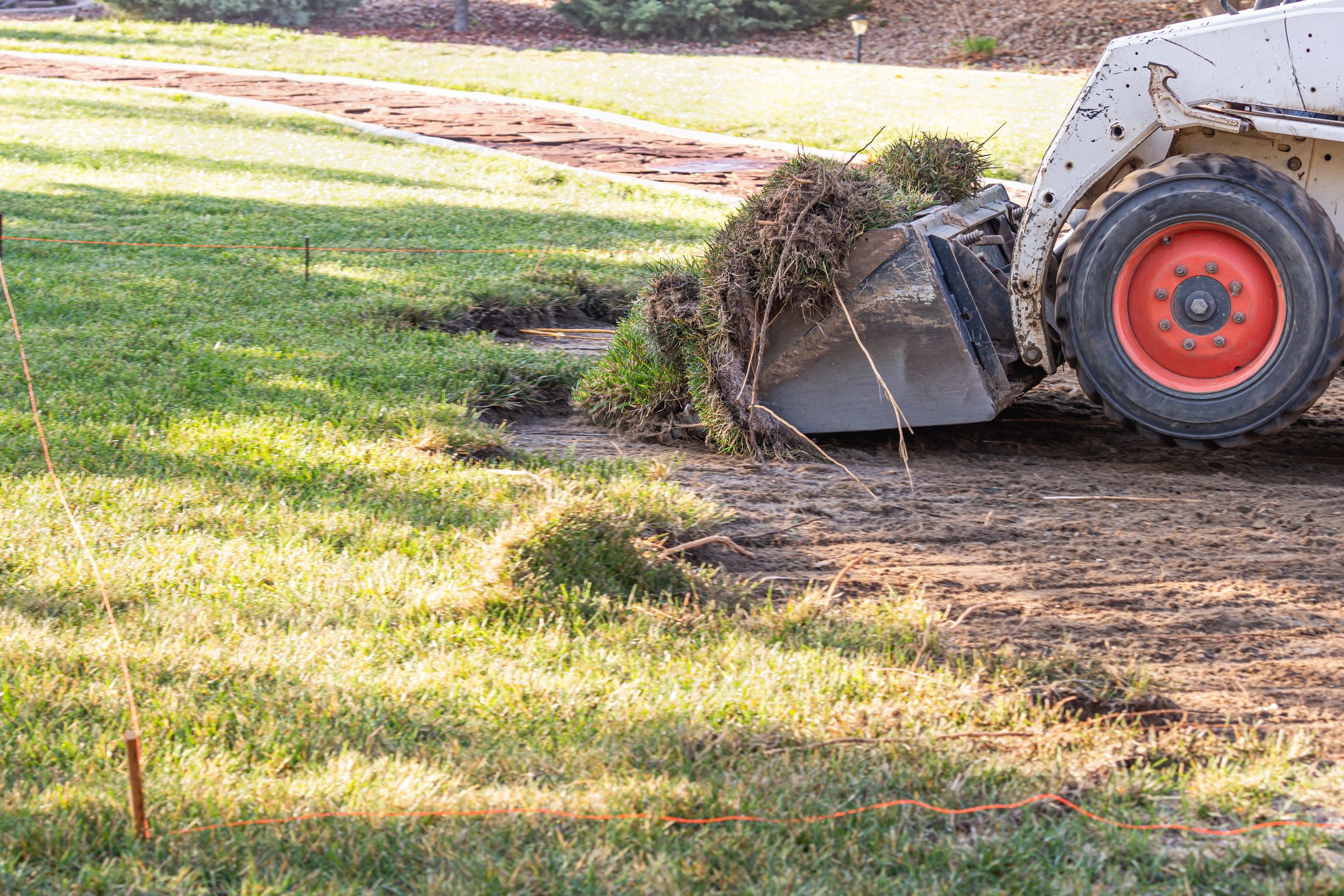 Small Bulldozer Removing Grass from Yard Preparing for Pool Inst