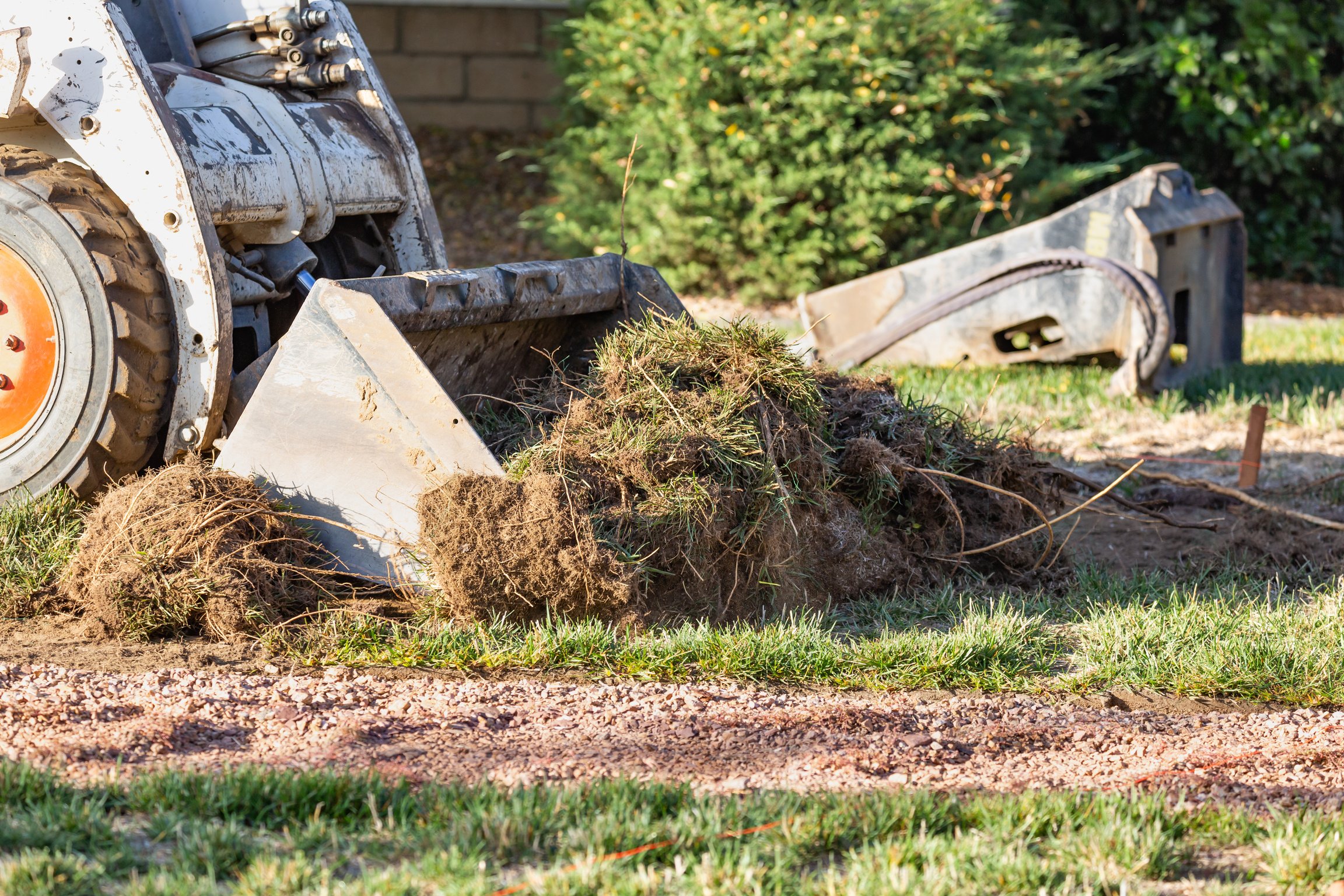 Small Bulldozer Removing Grass from Yard